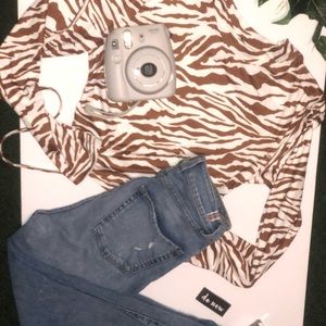 A zebra print crop top with a back opening